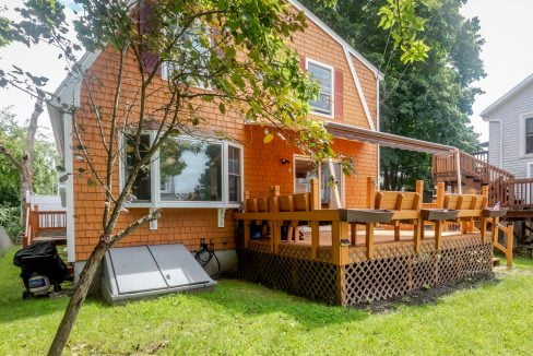 An orange house with a deck in the backyard.