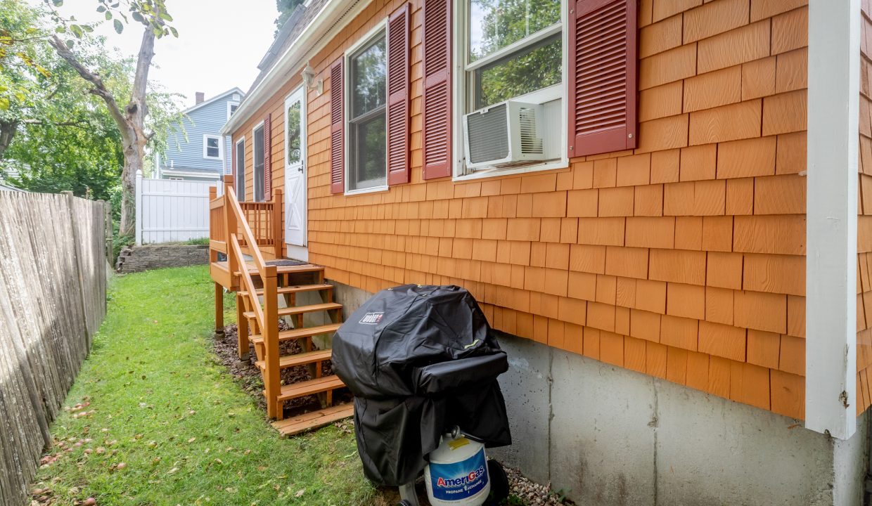 A backyard with an orange shingled house.