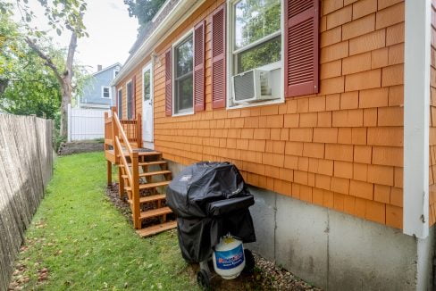 A backyard with an orange shingled house.