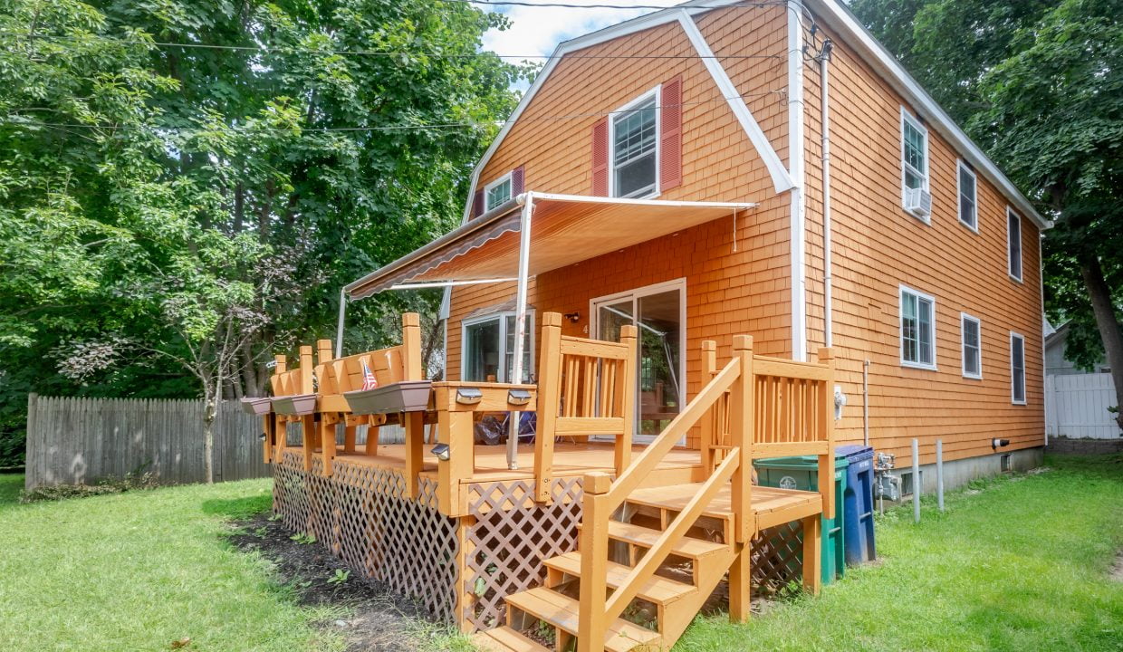 An orange house with a wooden deck and stairs.