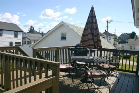 A wooden deck with a table and chairs.