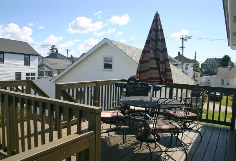 A wooden deck with a table and chairs.