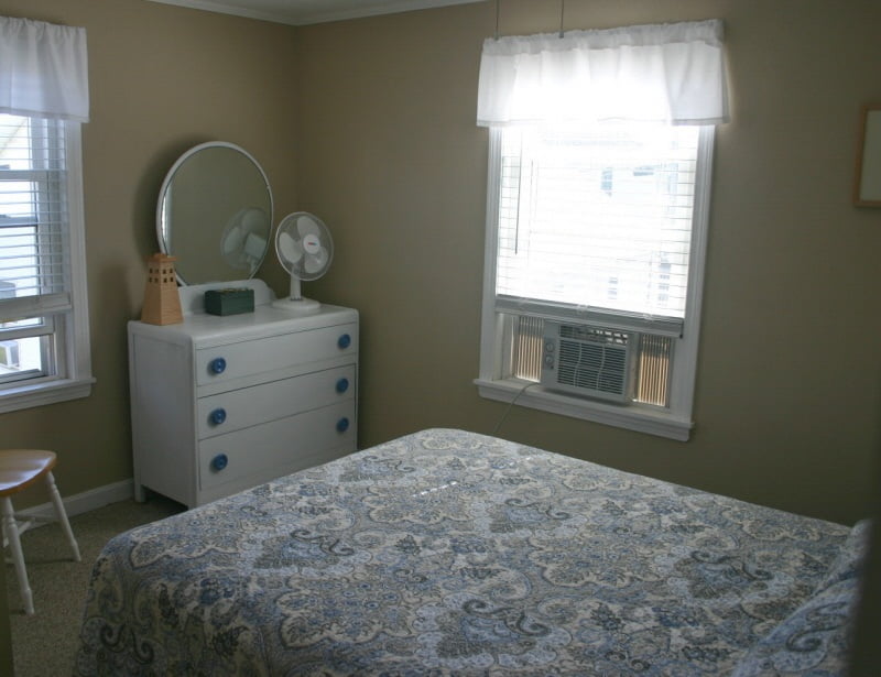 A small bedroom with a bed and a dresser.