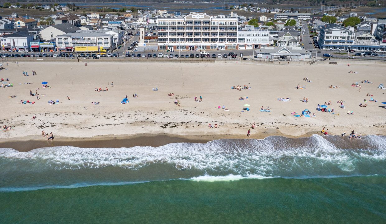 An aerial view of a beach with a lot of people on it.