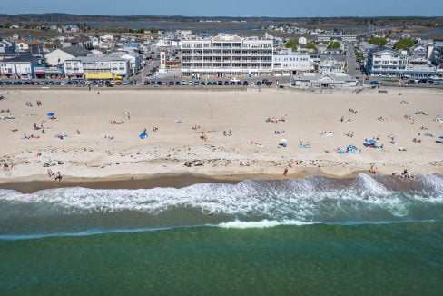 An aerial view of a beach with a lot of people on it.