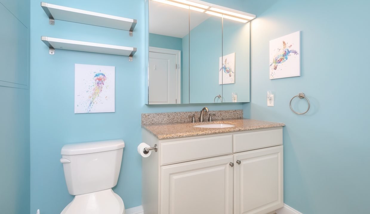 A bathroom with blue walls and a toilet.