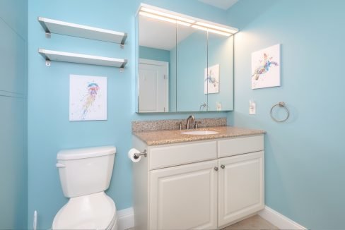 A bathroom with blue walls and a toilet.