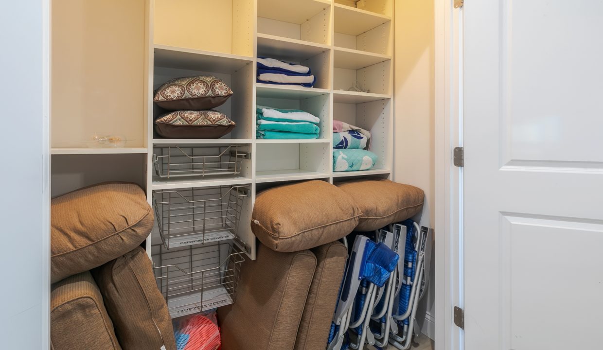 A closet with chairs and towels in it.