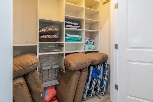 A closet with chairs and towels in it.