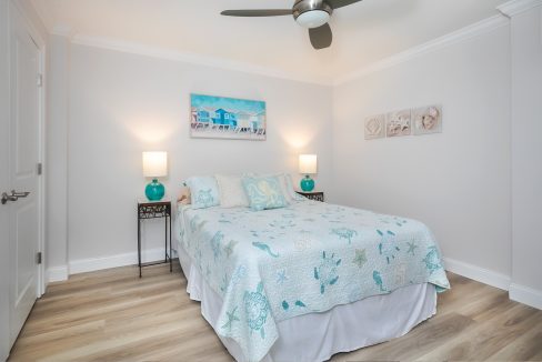 A bedroom with a bed and a ceiling fan.