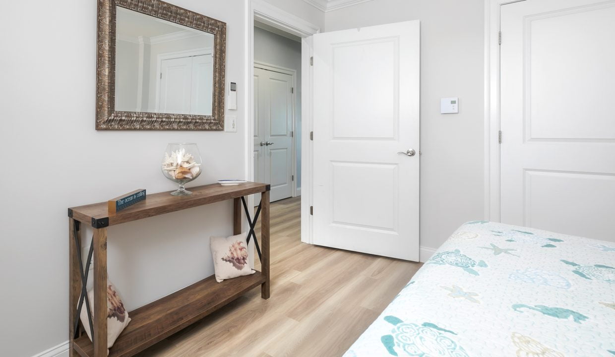 A bedroom with white doors and a wooden table.