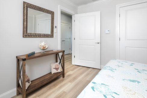 A bedroom with white doors and a wooden table.