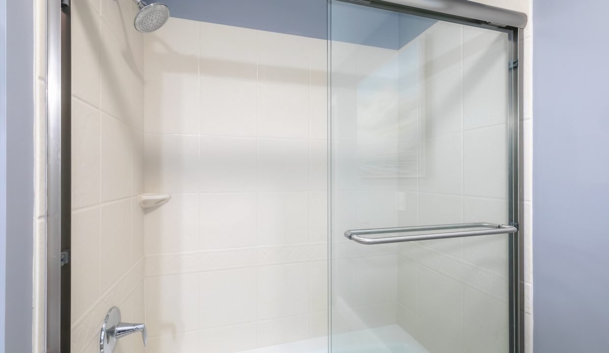 A bathroom with a glass shower door.