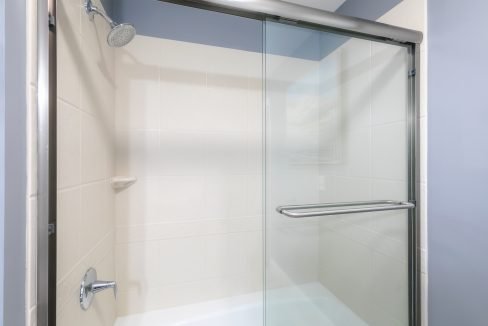 A bathroom with a glass shower door.