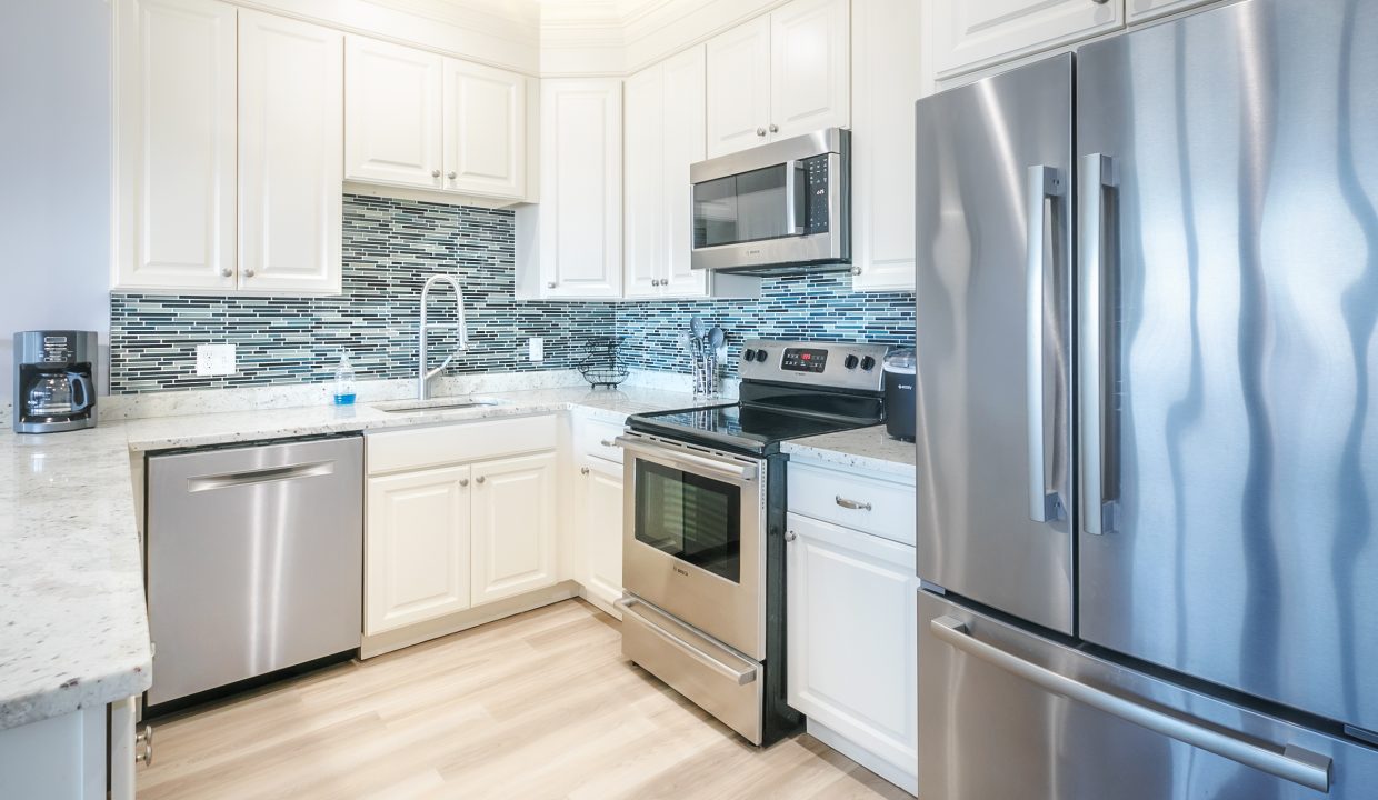 A kitchen with stainless steel appliances and white cabinets.