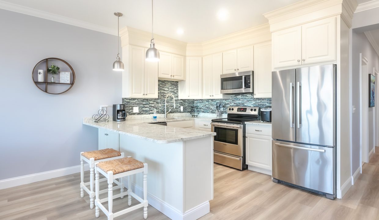 A kitchen with white cabinets and stainless steel appliances.