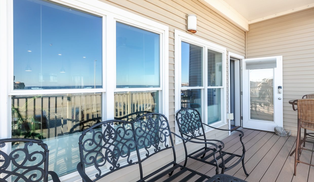 A balcony with chairs and a view of the ocean.