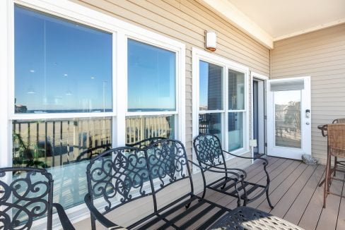 A balcony with chairs and a view of the ocean.