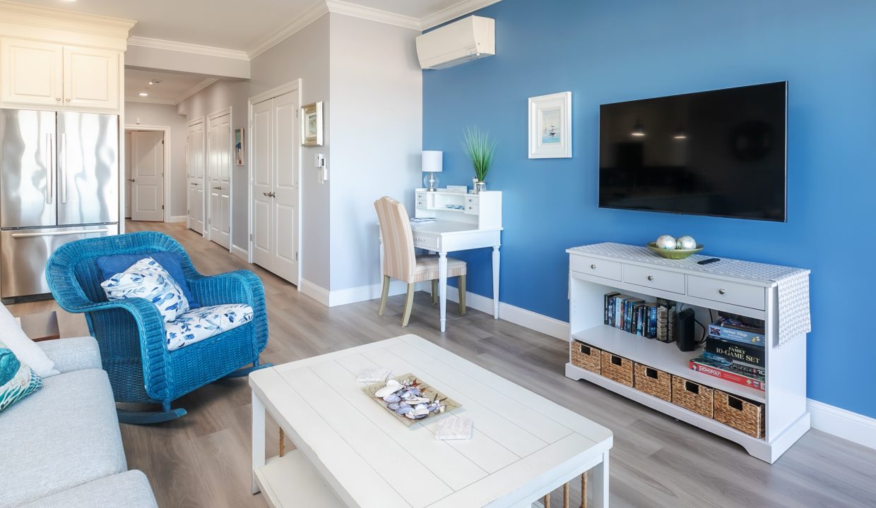 A living room with blue walls and white furniture.
