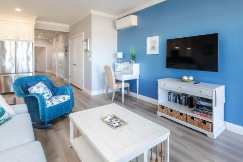 A living room with blue walls and white furniture.