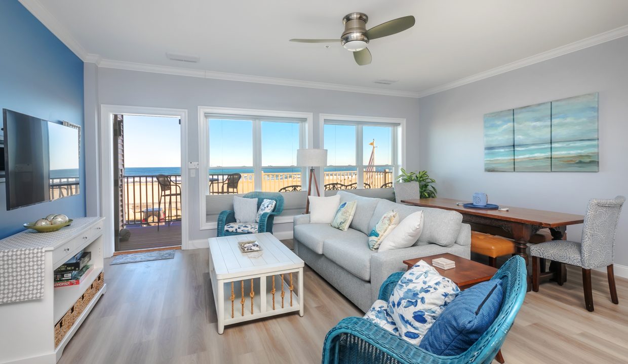 A living room with blue furniture and a view of the ocean.