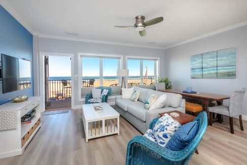 A living room with blue furniture and a view of the ocean.