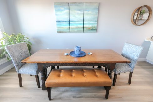 A table with a blue plate and two chairs.