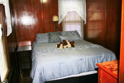 A bed with a teddy bear on it.