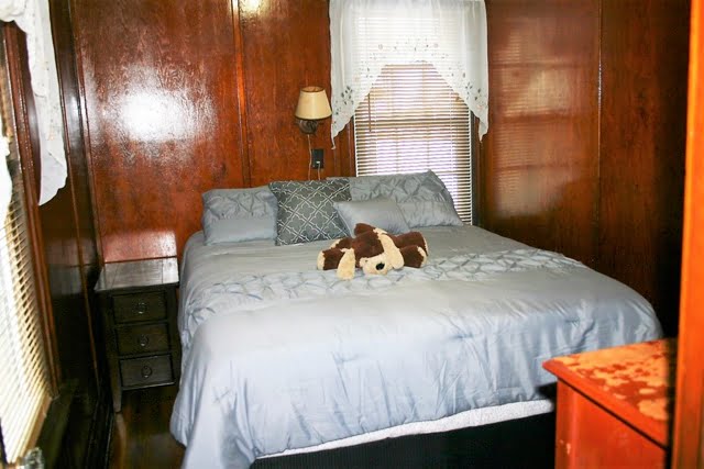 A bed with a teddy bear on it.