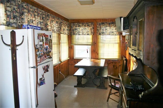 A kitchen with wood paneling and a refrigerator.