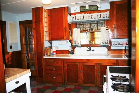 A kitchen with wooden cabinets and a stove.