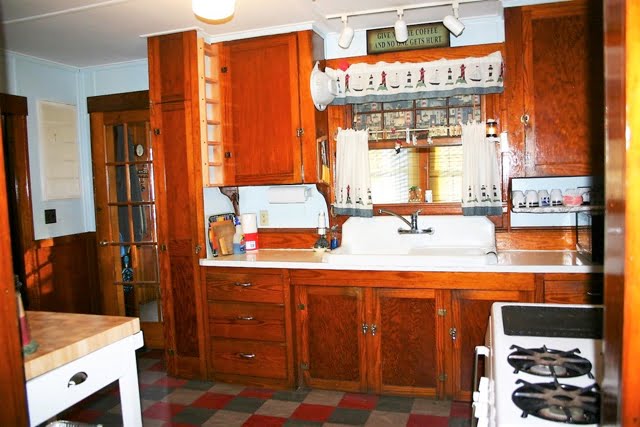 A kitchen with wooden cabinets and a stove.