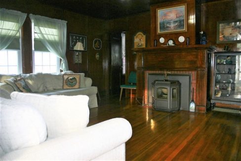 A living room with wood floors and a fireplace.
