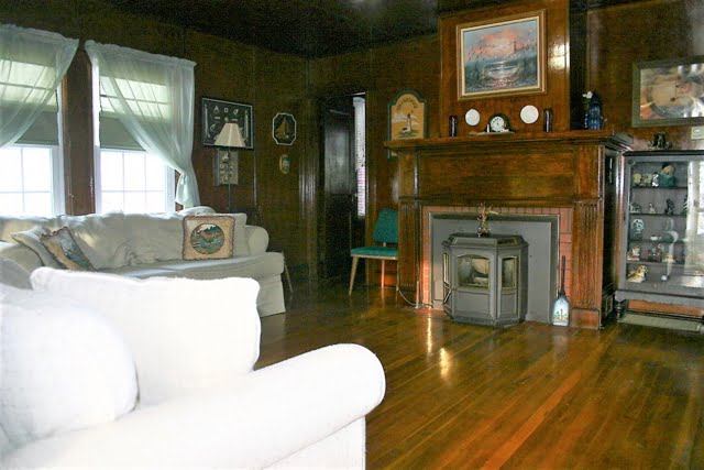 A living room with wood floors and a fireplace.