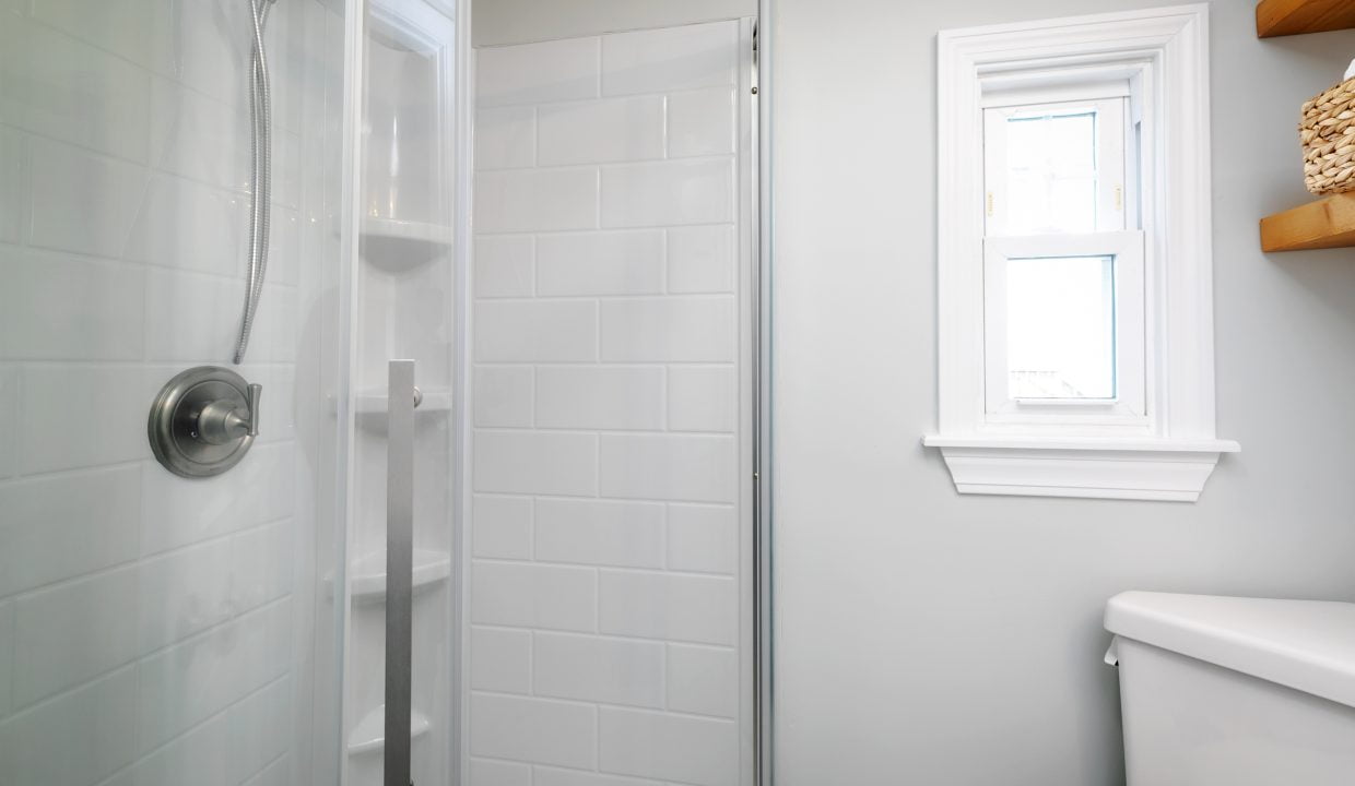 A bathroom with a toilet and a shower stall.