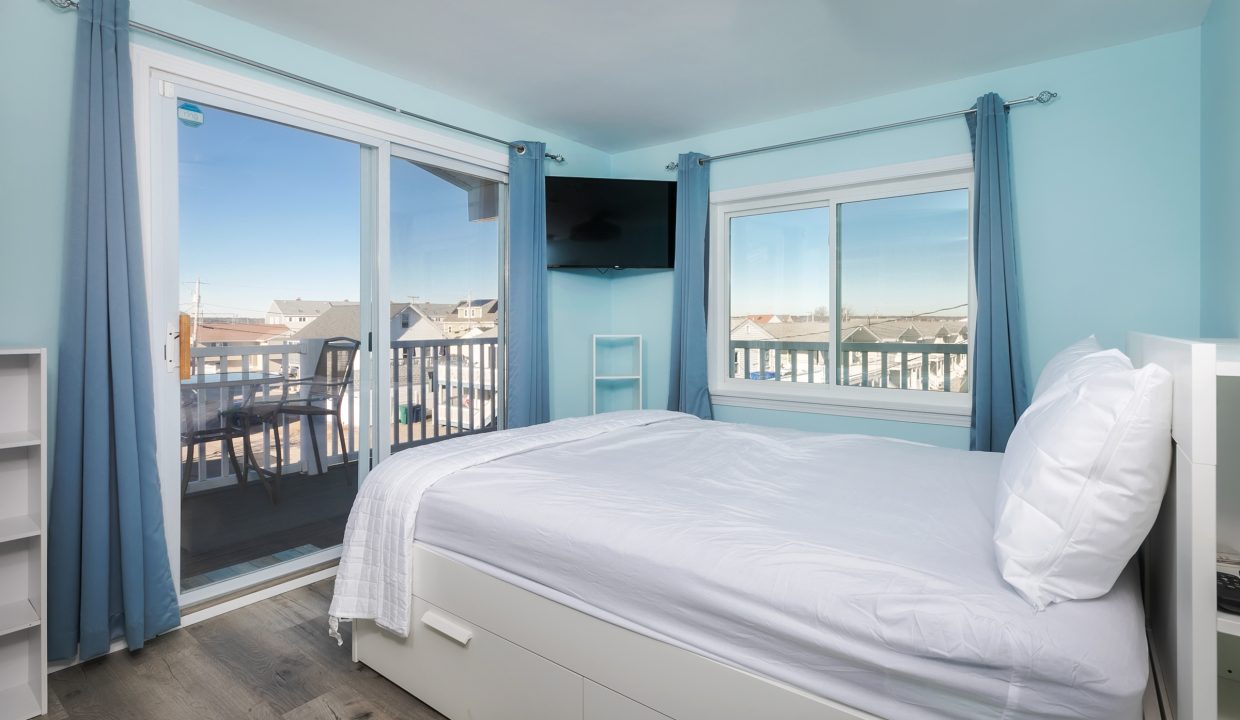 A bedroom with blue walls and a balcony.