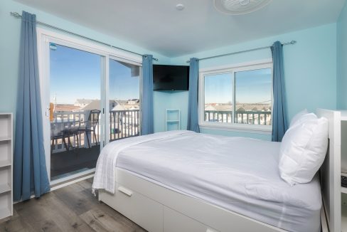 A bedroom with blue walls and a balcony.