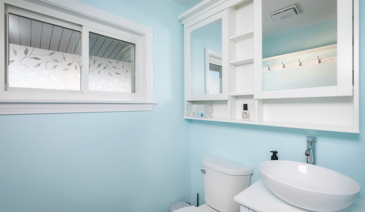 A bathroom with blue walls and a white toilet.