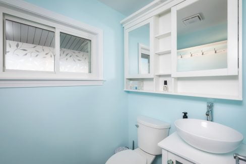 A bathroom with blue walls and a white toilet.