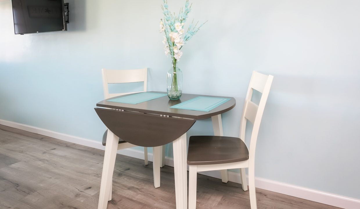 A small table and chairs in a room with blue walls.