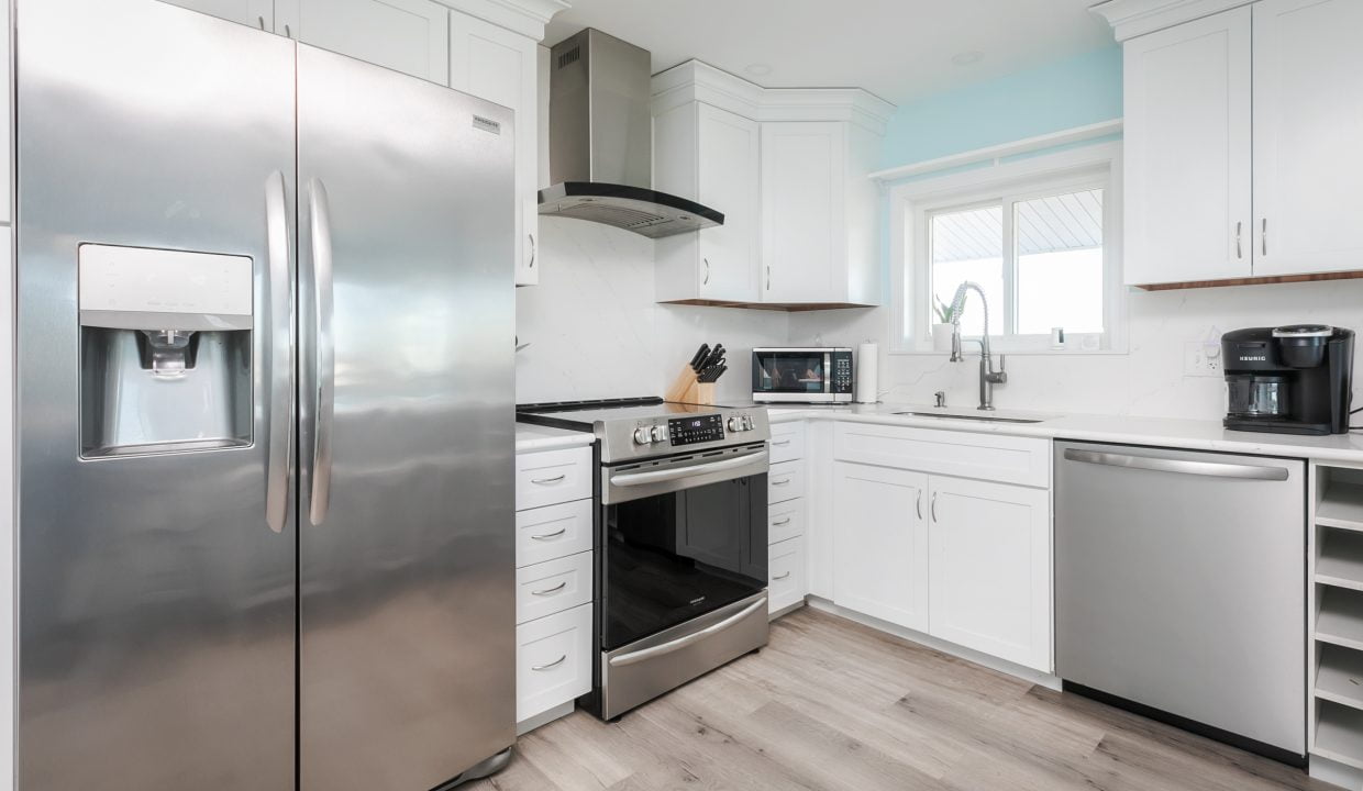 A kitchen with stainless steel appliances and white cabinets.