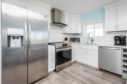 A kitchen with stainless steel appliances and white cabinets.