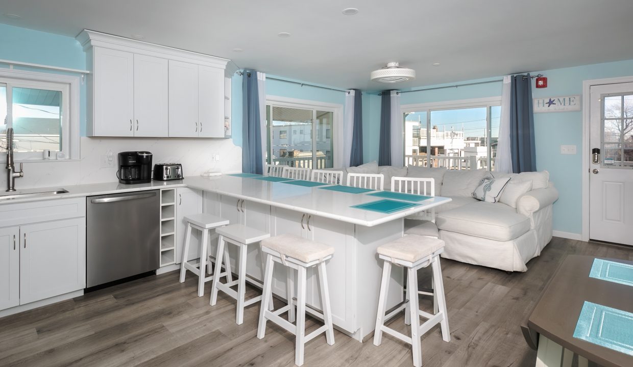 A kitchen with blue walls and white counter tops.