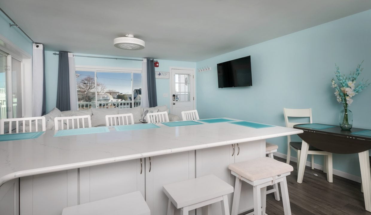 A kitchen with blue walls and white counter tops.