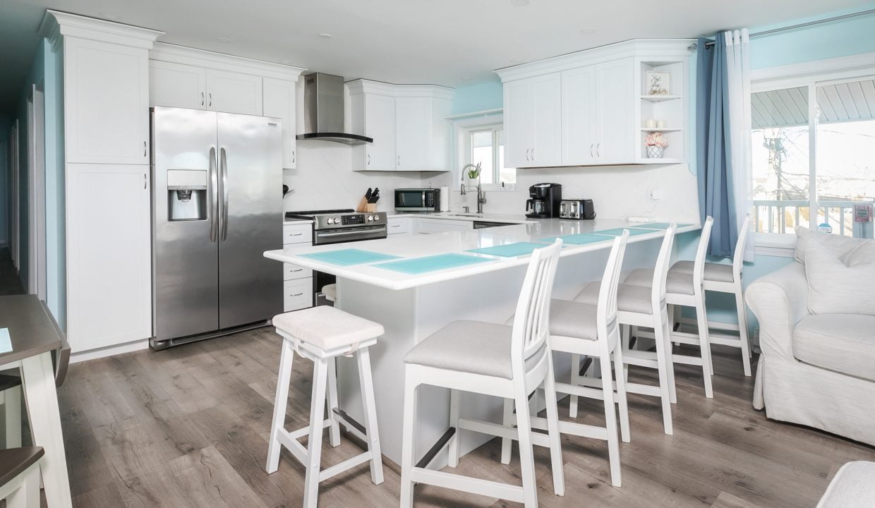 A kitchen with blue walls and white counter tops.