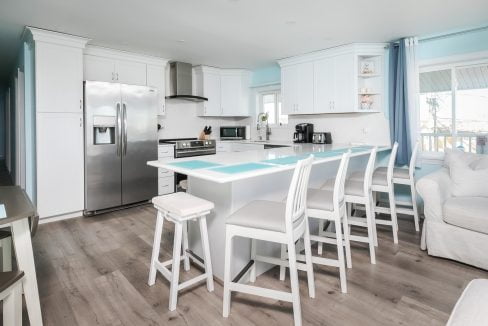 A kitchen with blue walls and white counter tops.