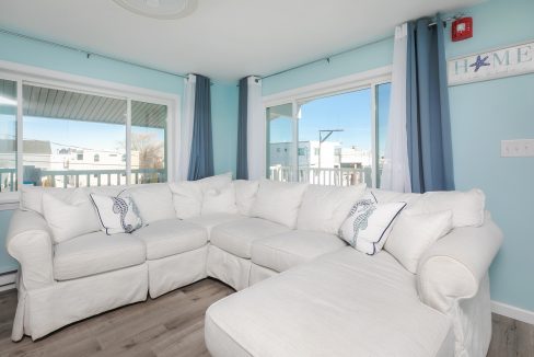 A living room with blue walls and white furniture.