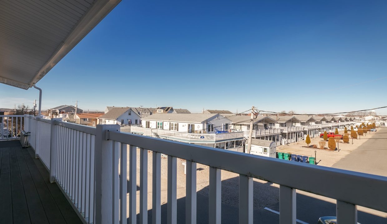 A balcony with a view of the ocean and buildings.