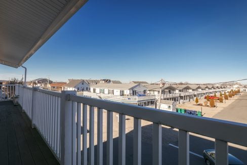 A balcony with a view of the ocean and buildings.