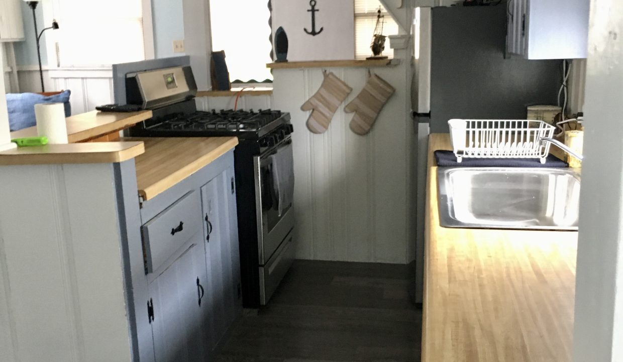 A kitchen in a tiny house with a stove and sink.